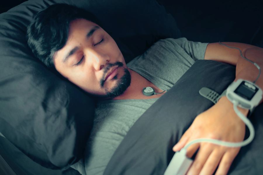 A patient asleep at home wearing a home sleep test sensor