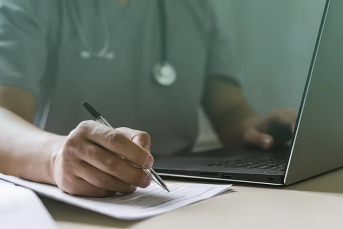 A physician completing medical paperwork