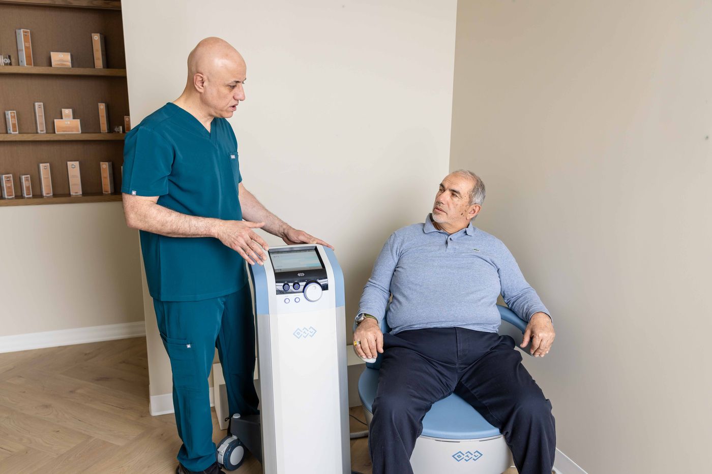 Dr. Sabah Jarullah with a male patient on the EMSELLA® chair at Westside, Calgary SW