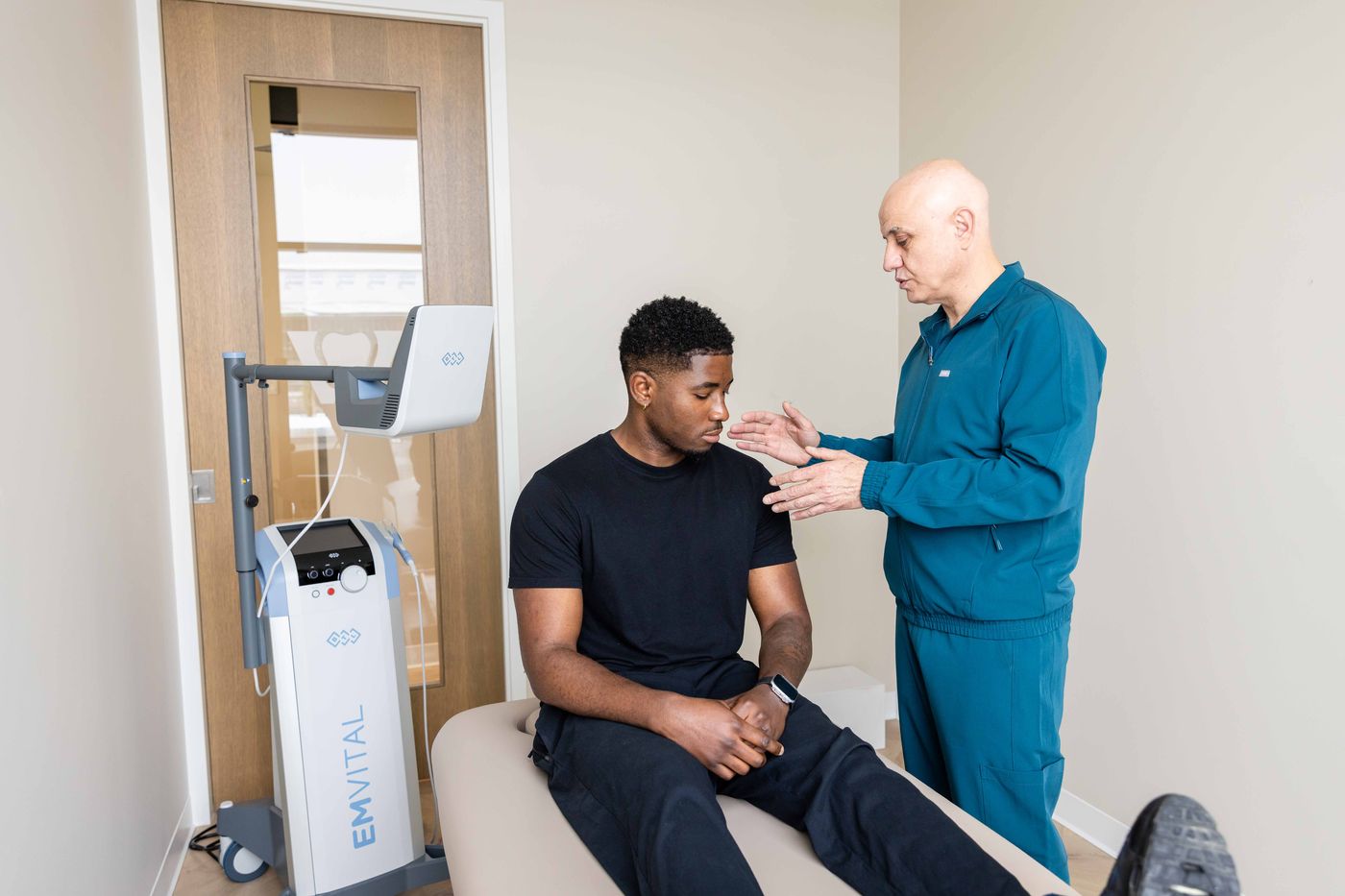 Dr. Sabah Jarullah assessing a patient's pain before EMVITAL® therapy at Westside, Calgary SW