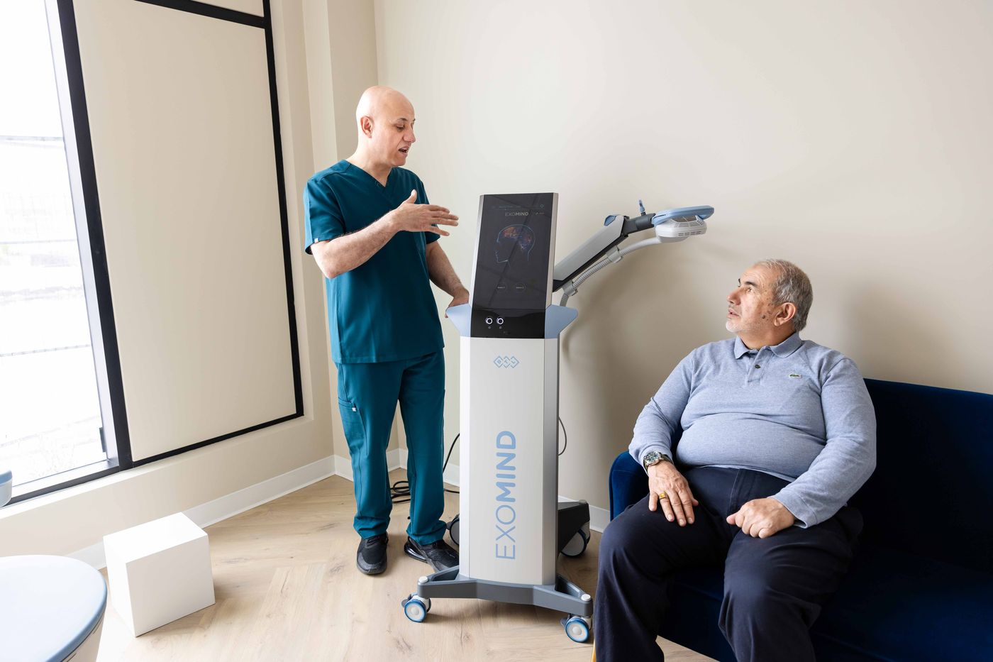 Dr. Sabah Jarullah explaining EXOMIND™ TMS to a patient at Westside, Calgary SW